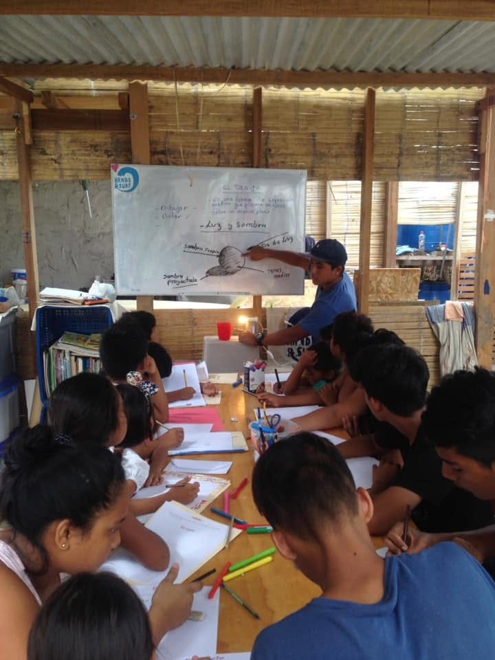 Taller educativo: niños dibujando mientras un instructor explica en la pizarra